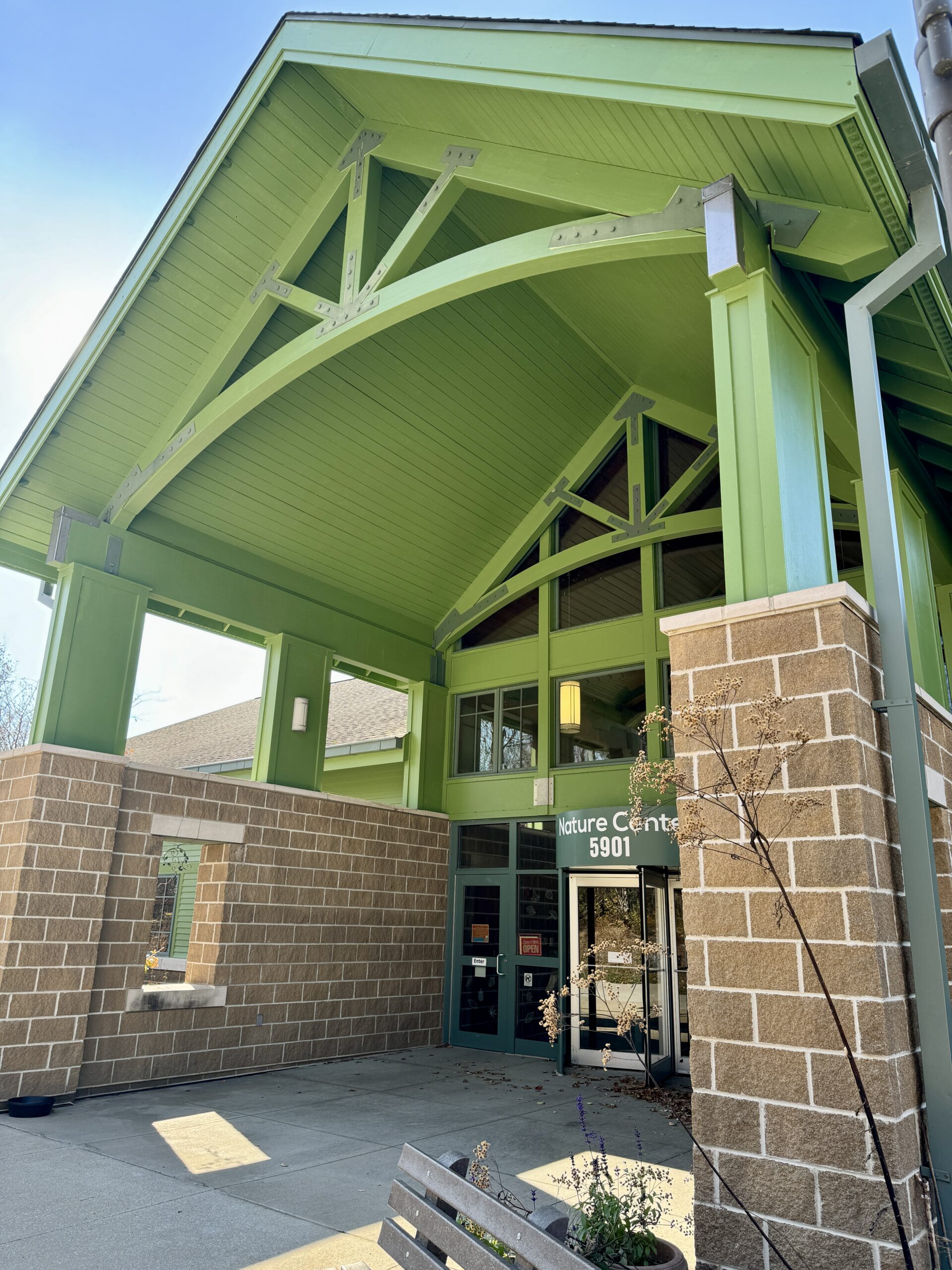 Entrance of a nature center featuring a green roof and stone walls.