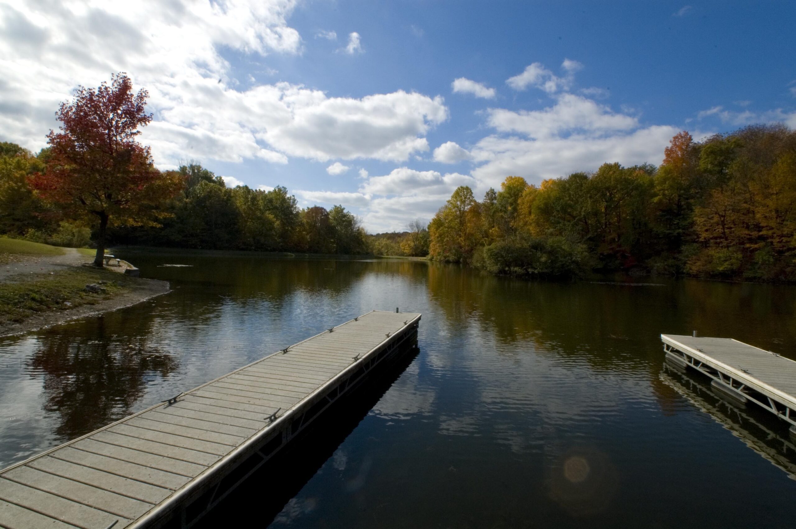 View of Lilly Lake with wooden docks and autumn foliage reflecting in the water.